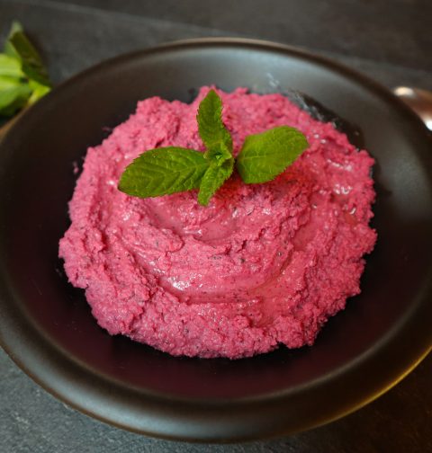 pink beetroot hummus in a black bowl